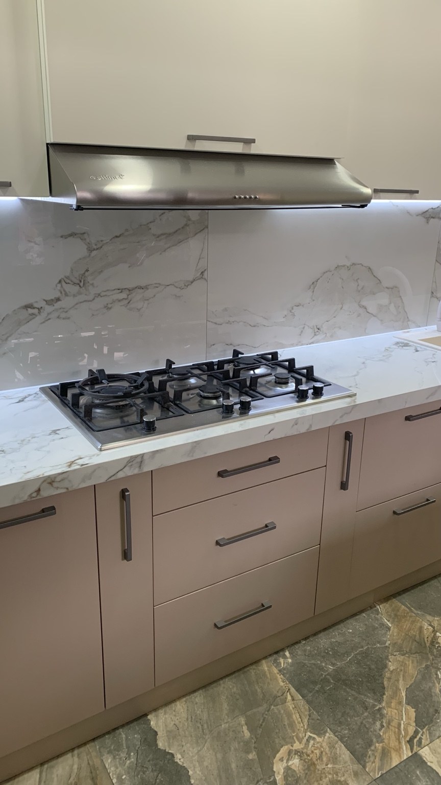 Marble-look kitchen backsplash behind cooktop
