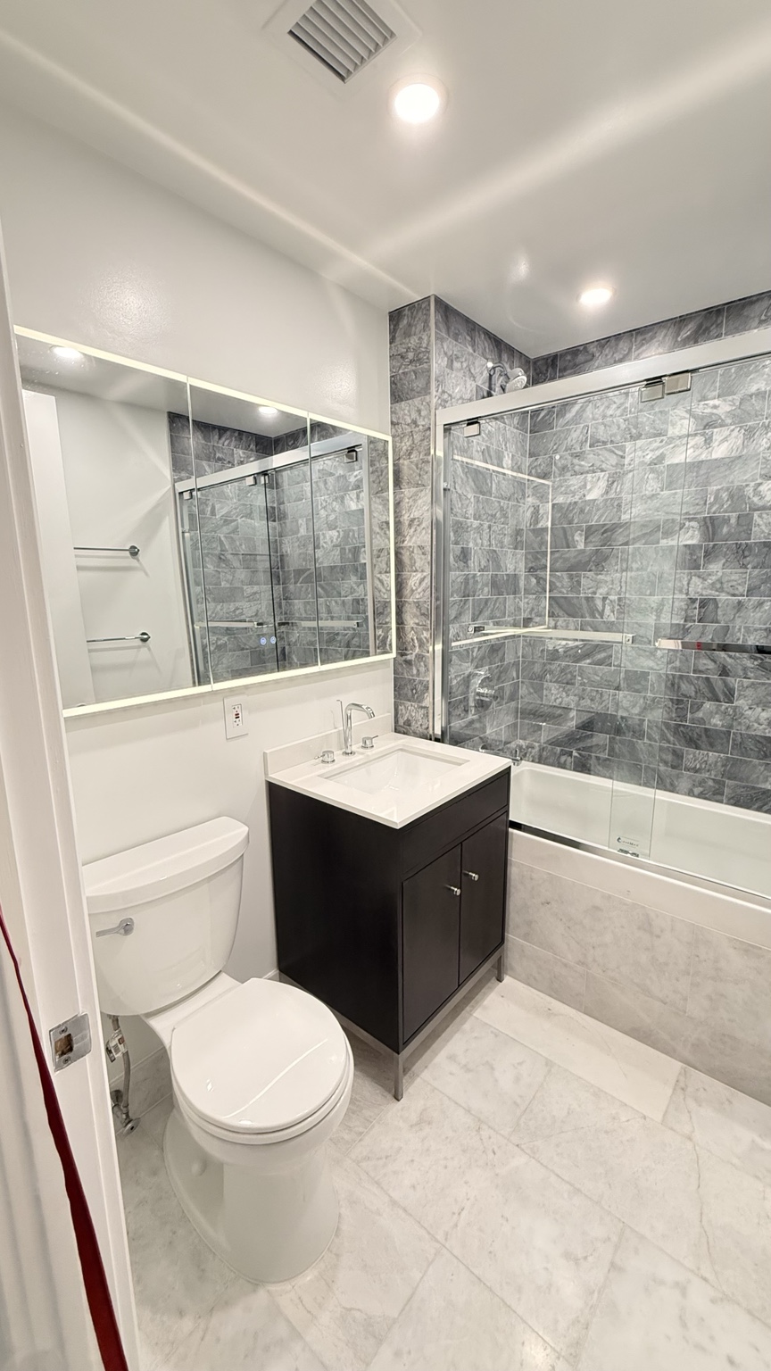 Marble-look bathroom with tiled tub surround
