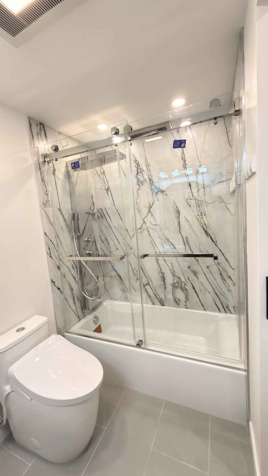 Marble-look bathtub and glass doors