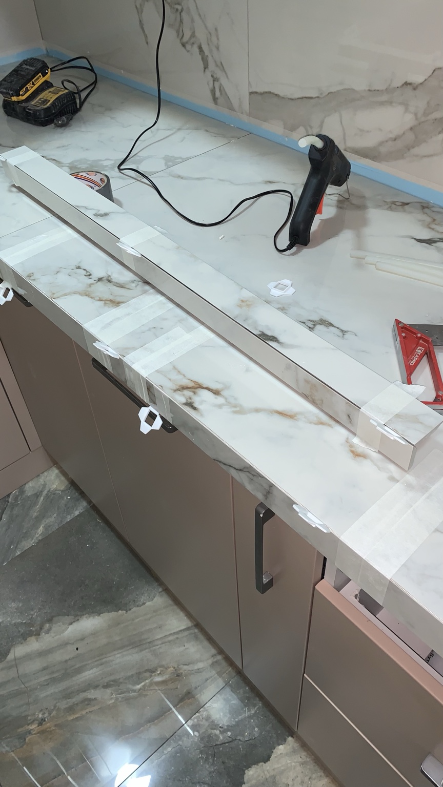 Floating dark tile vanity with mitered edges